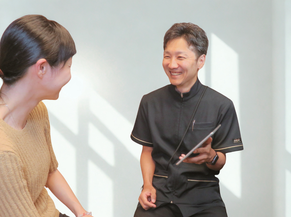 院長がお客様と笑顔で会話をしながらカウンセリングをしている様子